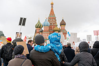 Rear view of people at temple against sky in city