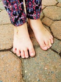 Low section of girl standing on footpath