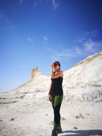 Full length of woman standing at desert against sky