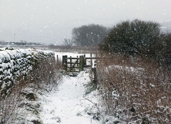 Snow covered landscape against sky