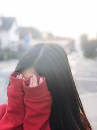 Close-up of young woman against sky