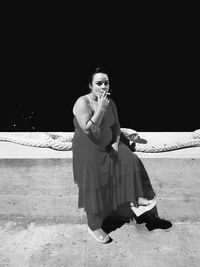 Portrait of young woman sitting on land