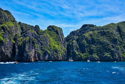 Scenic view of sea and mountains against blue sky