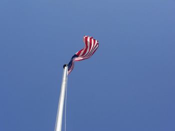 Low angle view of american flag against clear sky on sunny day