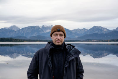 Portrait of man standing against lake