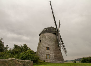 Low angle view of traditional windmill against sky