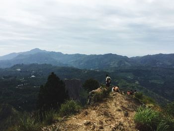 People on mountain against sky