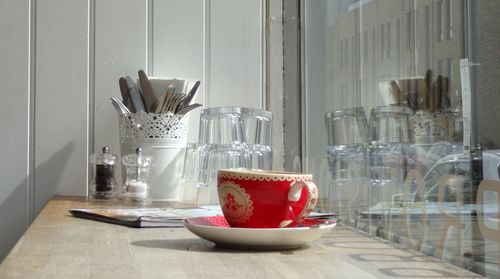 Red cup and saucer on wooden table