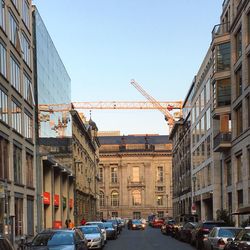 Cars on street in city against clear sky