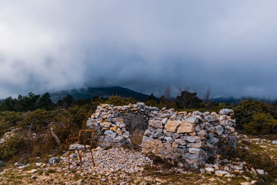 Stone wall on land against sky