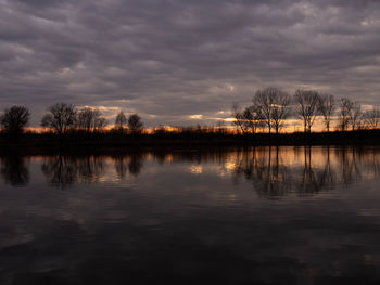 Scenic view of lake against sky at sunset