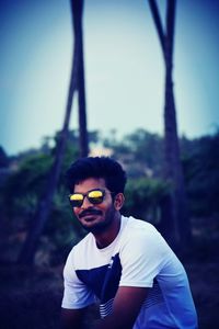 Portrait of young man wearing sunglasses standing outdoors