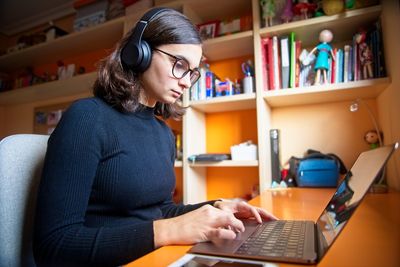 Young woman using mobile phone in laptop