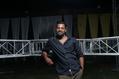 Portrait of smiling man standing by stage