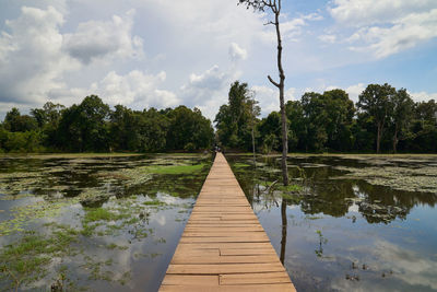 Wooden pier over lake against sky