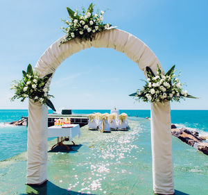 Wedding ceremony at beach against clear sky