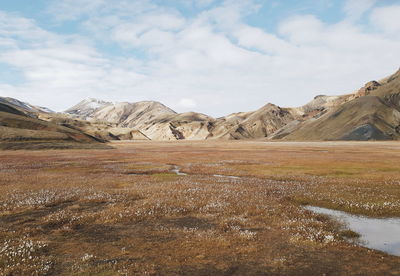 Scenic view of field and mountains against sky