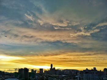 View of cityscape against cloudy sky