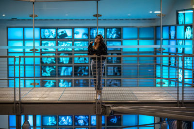 Portrait of woman standing by railing