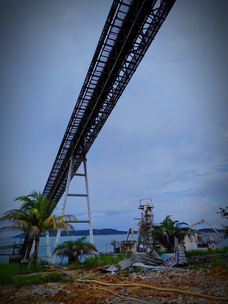 LOW ANGLE VIEW OF CRANE AGAINST BLUE SKY