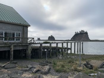 Exterior of old building by sea against sky