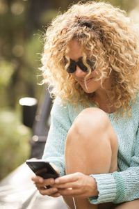 Smiling woman using smart phone outdoors