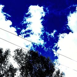 Low angle view of trees against blue sky