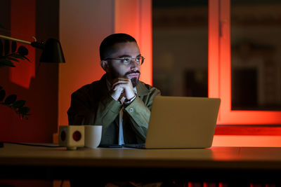 Pensive manager, web designer work late in empty closed coworking space. overwork time and overtime