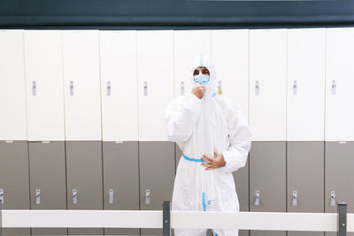 Healthcare man standing against locker in hospital