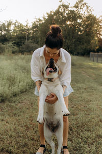 Happy young woman hugging and having fun with her labrador outdoors.