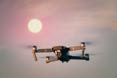 Close-up of camera against sky during sunset