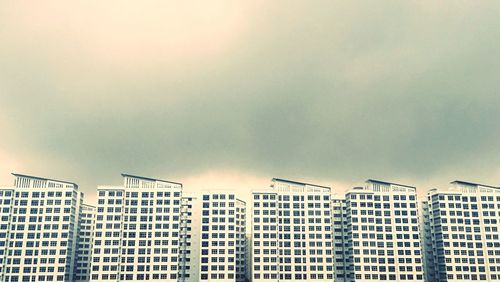 Low angle view of buildings against cloudy sky