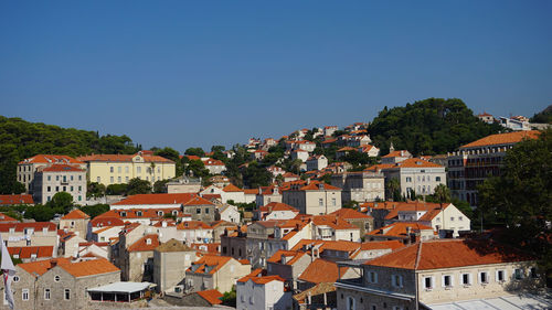 Houses in town against clear blue sky