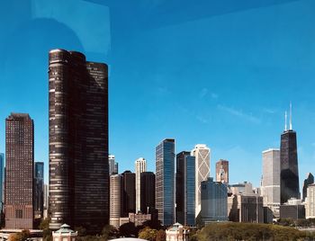 Modern buildings in city against blue sky