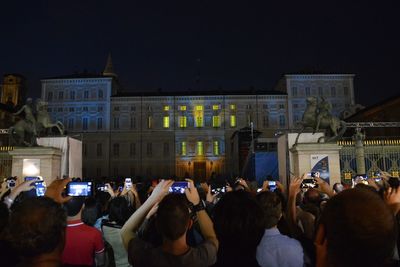 People photographing illuminated city at night