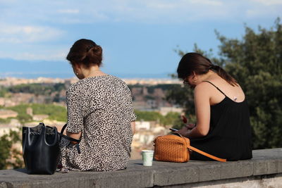 Rear view of women sitting outdoors