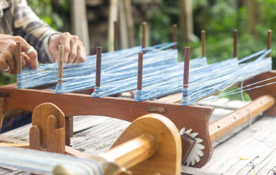 Close-up of hands working on loom