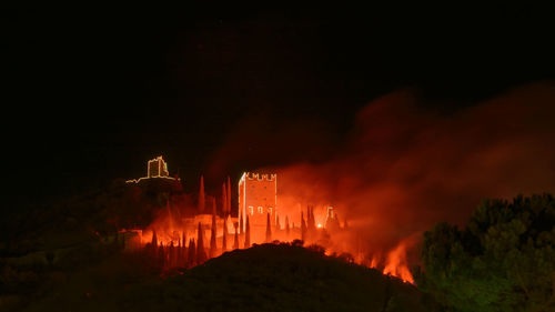 Panoramic view of illuminated bonfire against sky at night