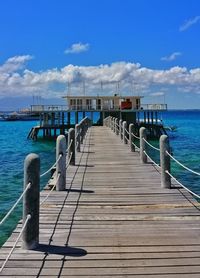 Pier over sea against blue sky