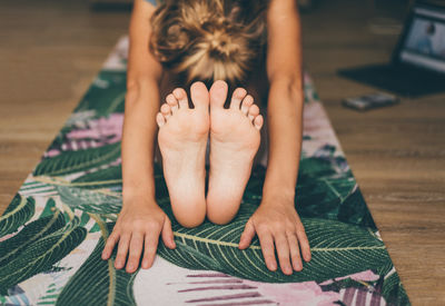 Midsection of woman sitting on floor at home