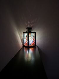 Close-up of illuminated electric lamp on table in darkroom