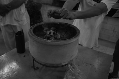 Midsection of man hands over container emitting smoke 