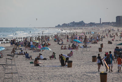 People at beach against clear sky