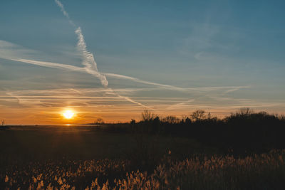 Scenic view of silhouette field against sky during sunset