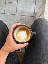 Low section of woman holding coffee cup