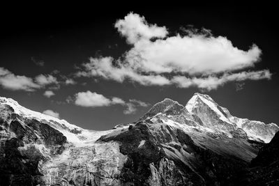 Scenic view of mountain range against cloudy sky