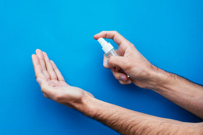 Close-up of man hand holding blue background