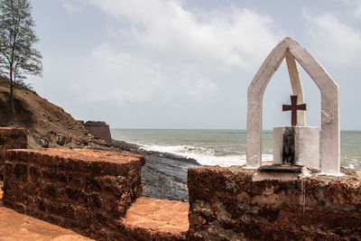 Built structure by sea against sky