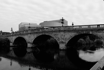 Arch bridge over river against sky