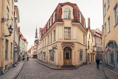 People walking on road amidst buildings in city